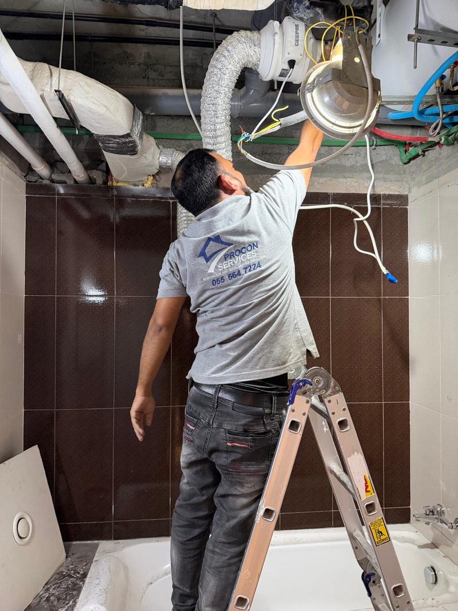 Procon team member cleaning an AC duct in a bathroom